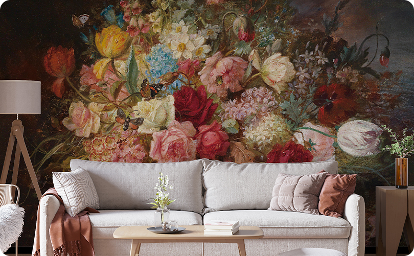 Colorful vintage floral wallpaper mural on a dark background behind a light gray sofa